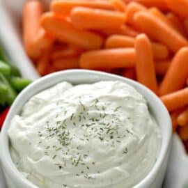 A small bowl of 3 Ingredient Cottage Cheese Vegetable Dip surrounded by veggies