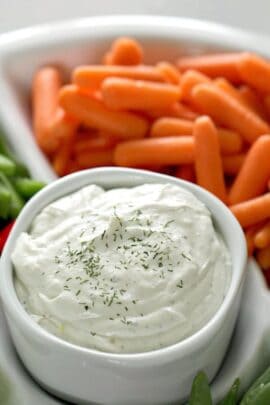 A small bowl of 3 Ingredient Cottage Cheese Vegetable Dip surrounded by veggies