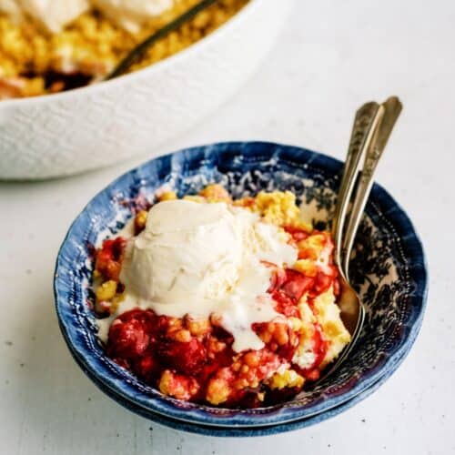 Cherry Cheesecake Dump Cake in a bowl topped with ice cream