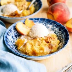 A serving of Peach Cobbler Dump Cake (4 Ingredients) in a bowl with ice cream