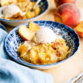 A serving of Peach Cobbler Dump Cake (4 Ingredients) in a bowl with ice cream