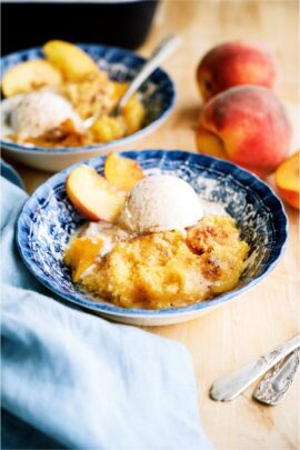 A serving of Peach Cobbler Dump Cake (4 Ingredients) in a bowl with ice cream.