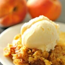 A slice of Slow Cooker Peach Cobbler topped with ice cream