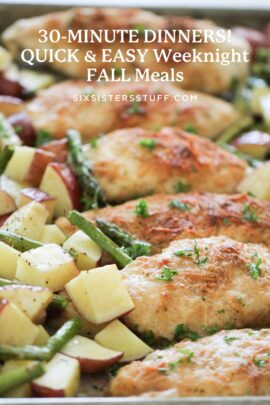 Sheet pan meal with seasoned chicken breasts, red potato cubes, and green beans, topped with fresh herbs.