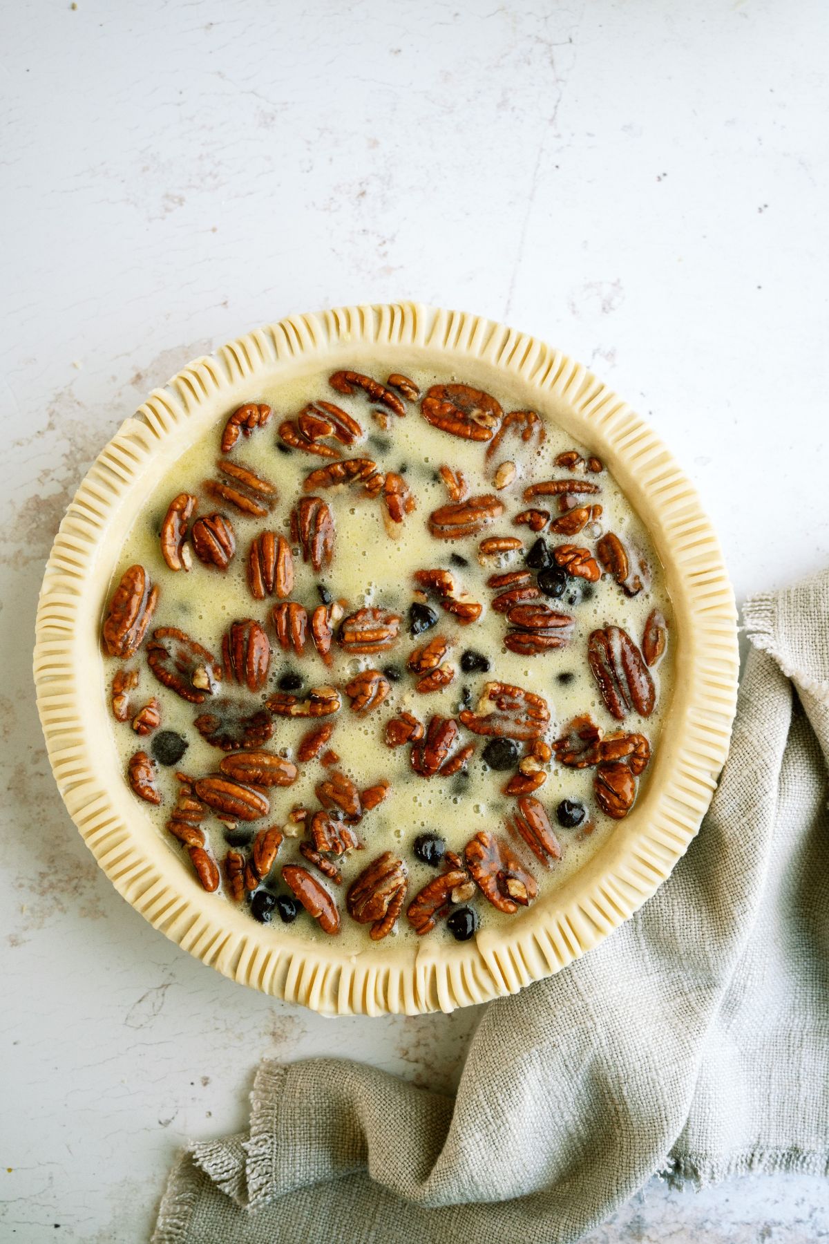 Unbaked Chocolate Pecan Pie in pie dish.