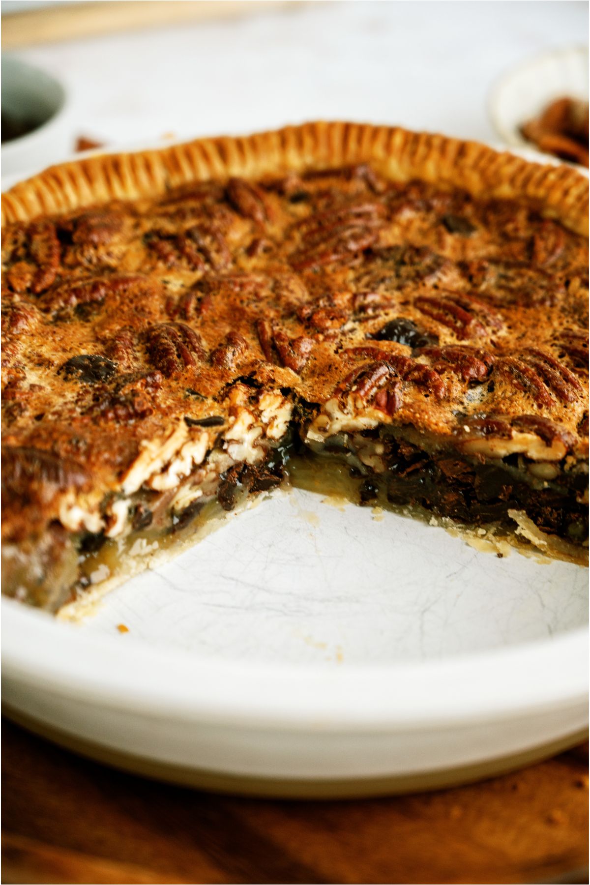 Baked Chocolate Pecan Pie in pie plate missing a few slices, showing the insides of the pie.