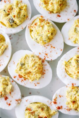 Close up of several Deviled Eggs on a white background.