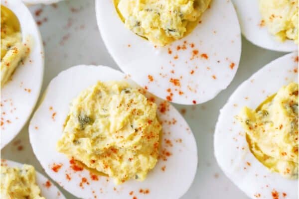 Close up of several Deviled Eggs on a white background.