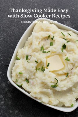 A bowl of mashed potatoes topped with butter and chopped chives.
