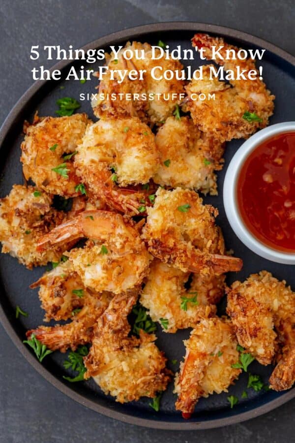 A plate of crispy, golden-brown shrimp with a side of red dipping sauce, garnished with parsley.