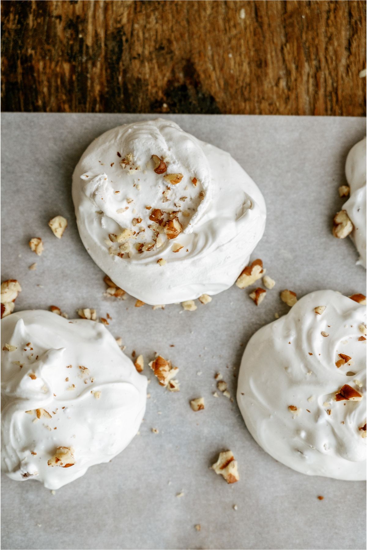 3 pieces of Divinity on wax paper topped with chopped pecan pieces.