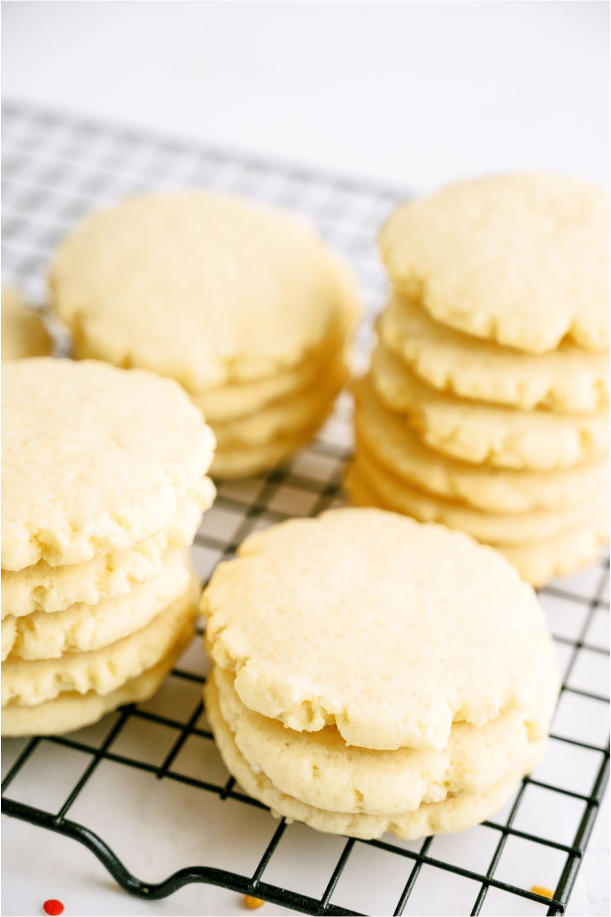 Super Soft Sugar Cookies unfrosted stacked in rows on a cooling rack.