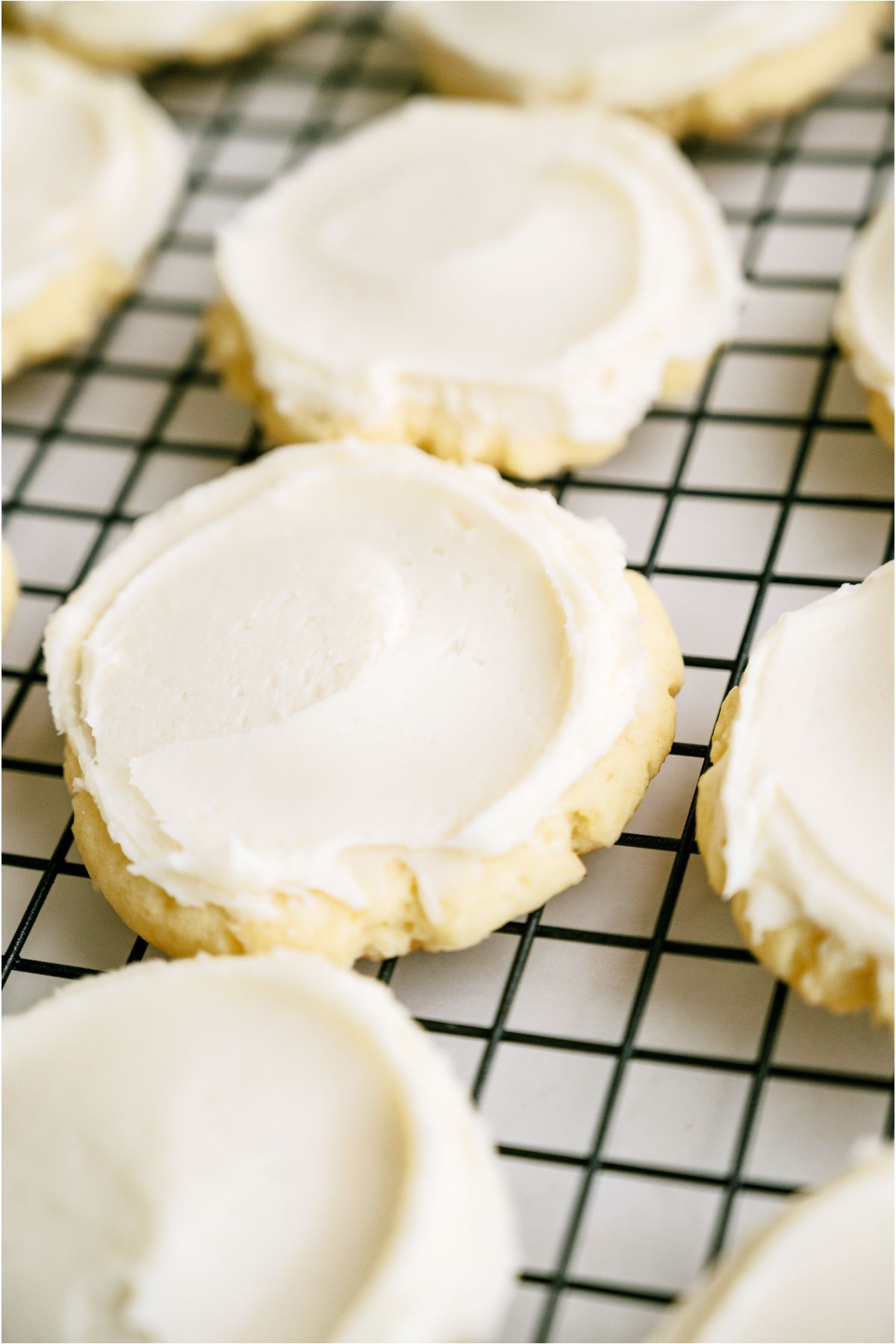 Super Soft Sugar Cookies frosted on a cooling rack.