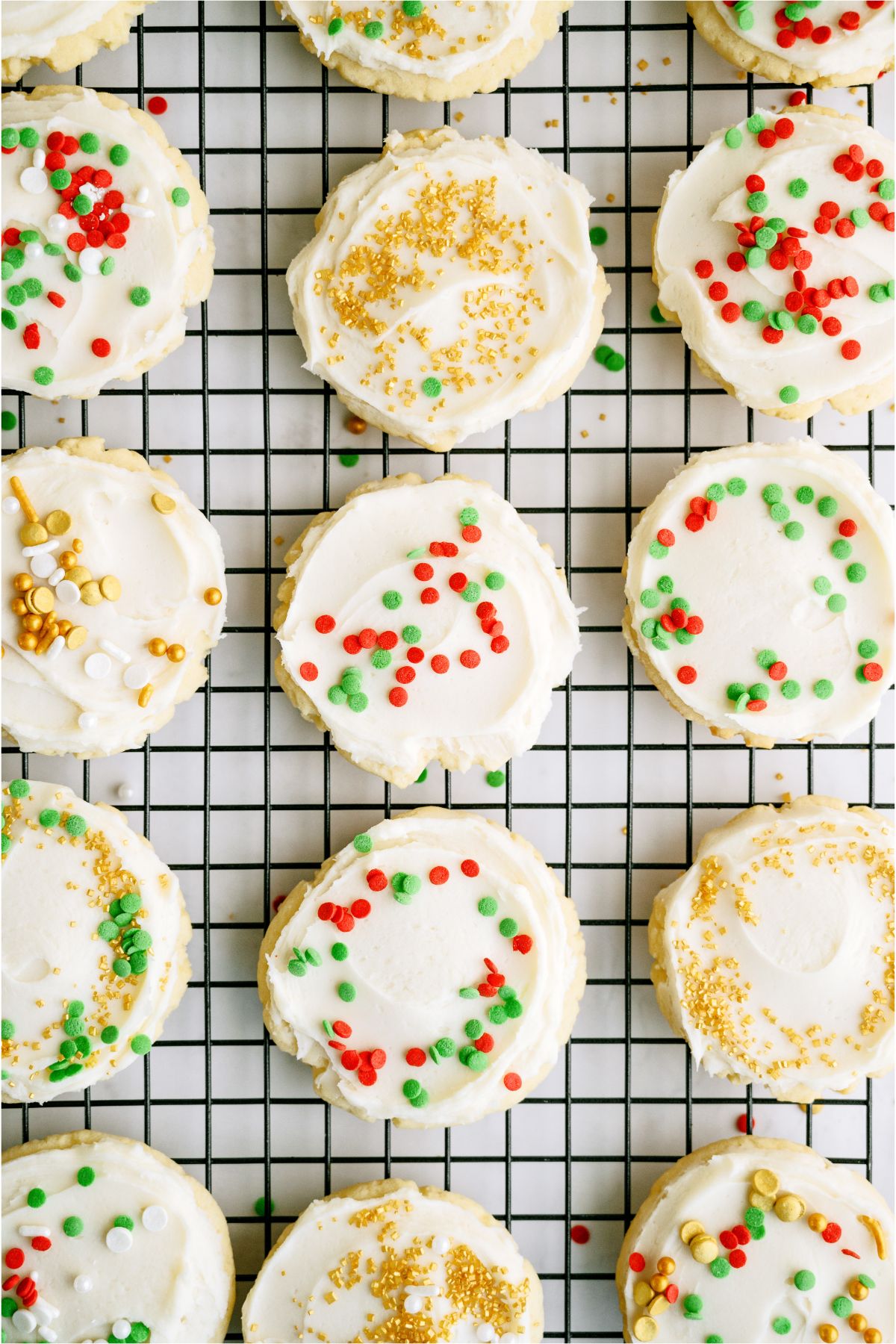 Super Soft Sugar Cookies frosted and with sprinkles on a cooling rack.