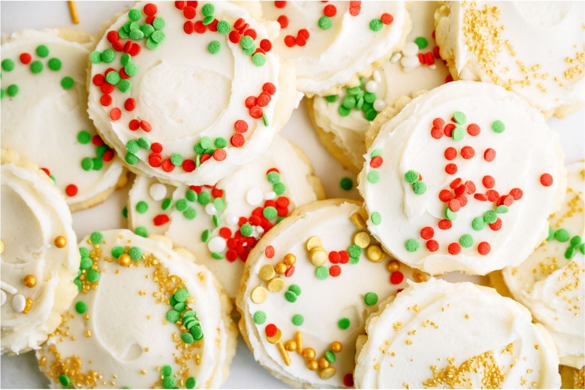 Frosted Super Soft Sugar Cookies with sprinkles stacked in a pile.