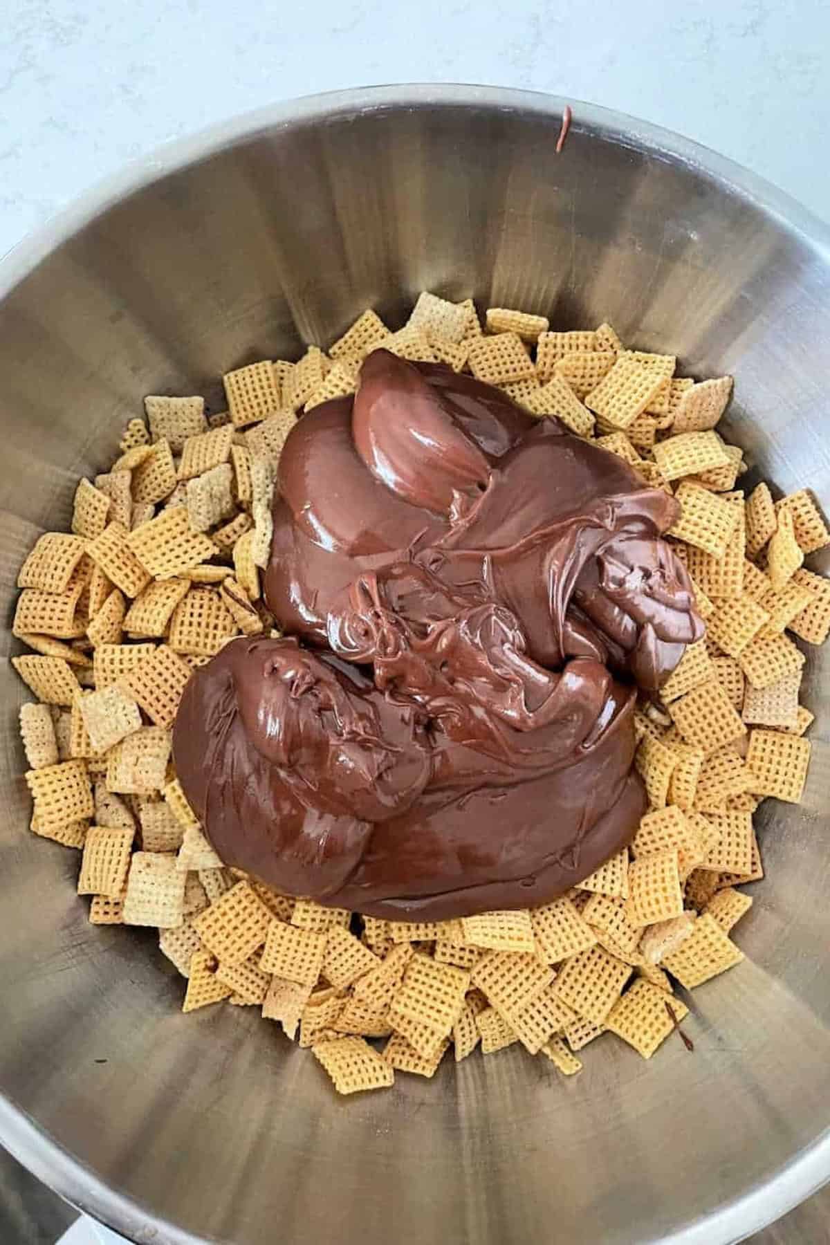 Bowl of Chex with a large dollop of chocolate spread on top.