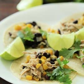 slow cooker cilantro lime chicken on a plate with limes