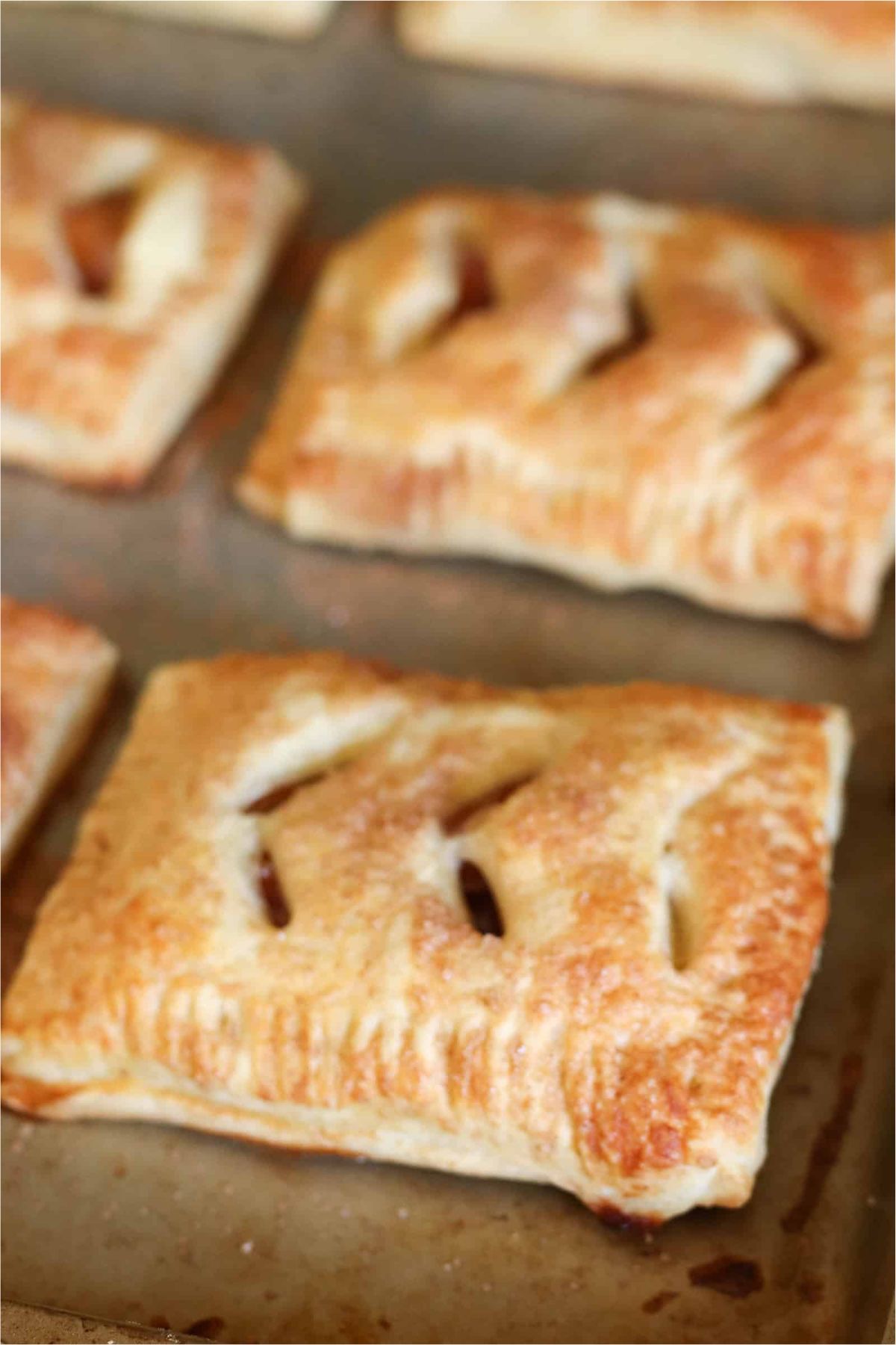 Golden Brown Baked Peach Hand Pies on a baking sheet.