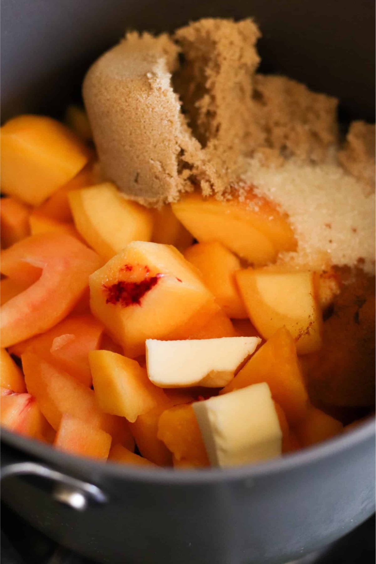 Diced peaches, brown sugar and butter in a mixing bowl.