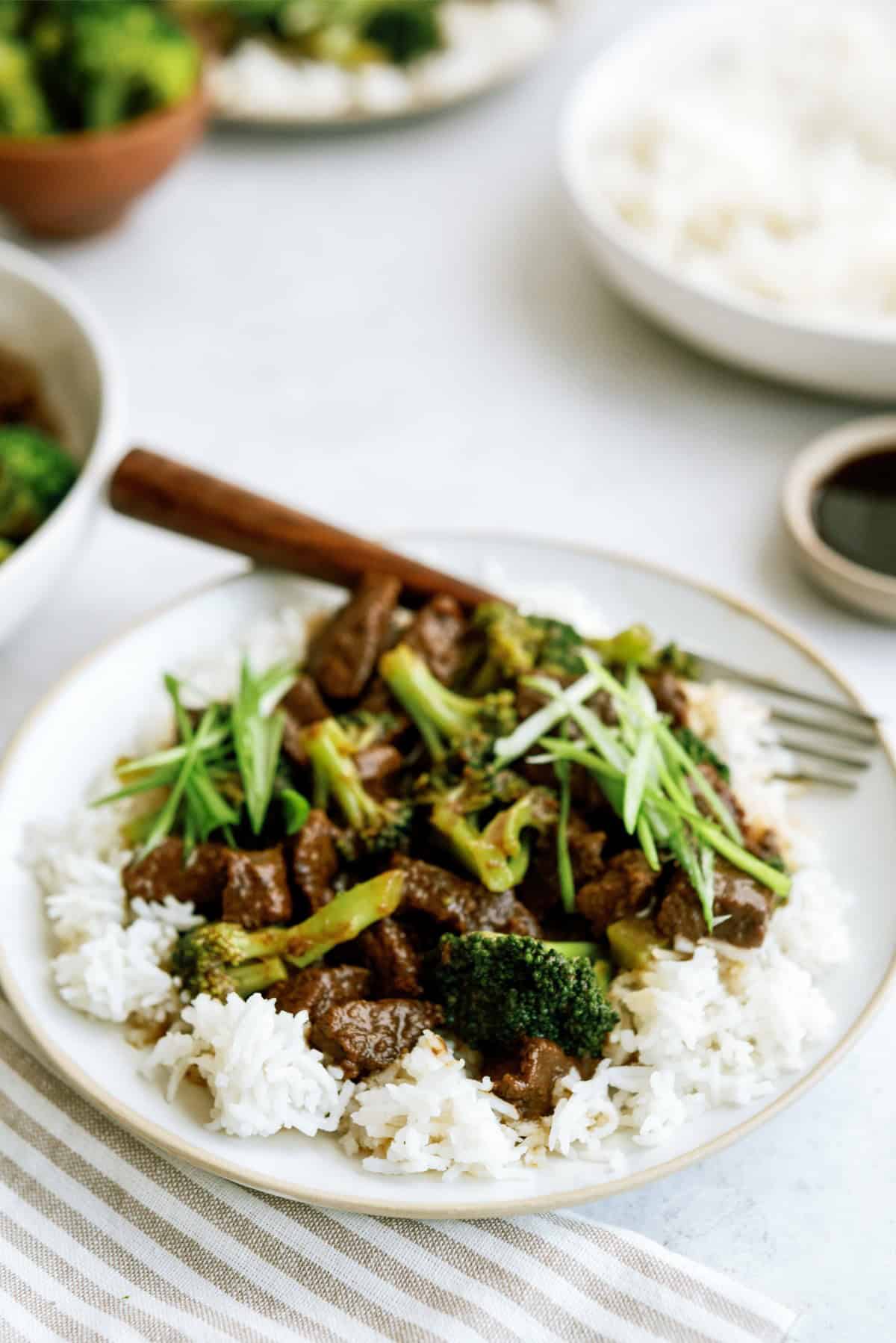 Instant Pot Beef and Broccoli served over rice on a plate with a fork