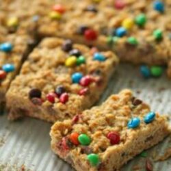 M&M Oatmeal Cookie Bars out of pan. First row cut into squares.