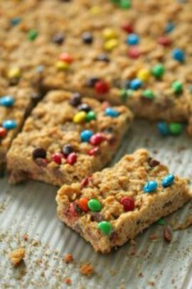 M&M Oatmeal Cookie Bars out of pan. First row cut into squares.