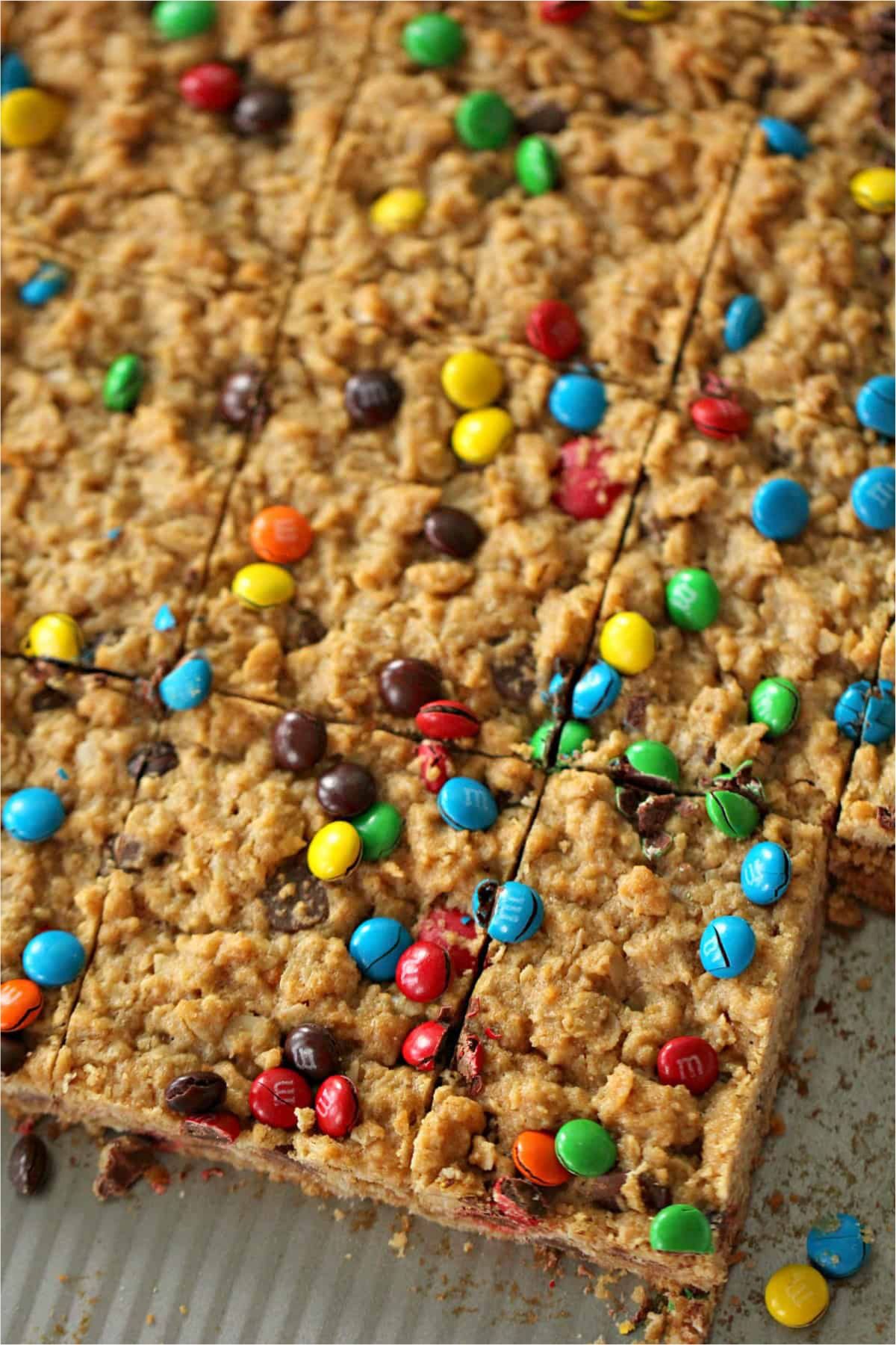 Top view of baked M&M Oatmeal Cookie Bars out of the pan and cut into squares.