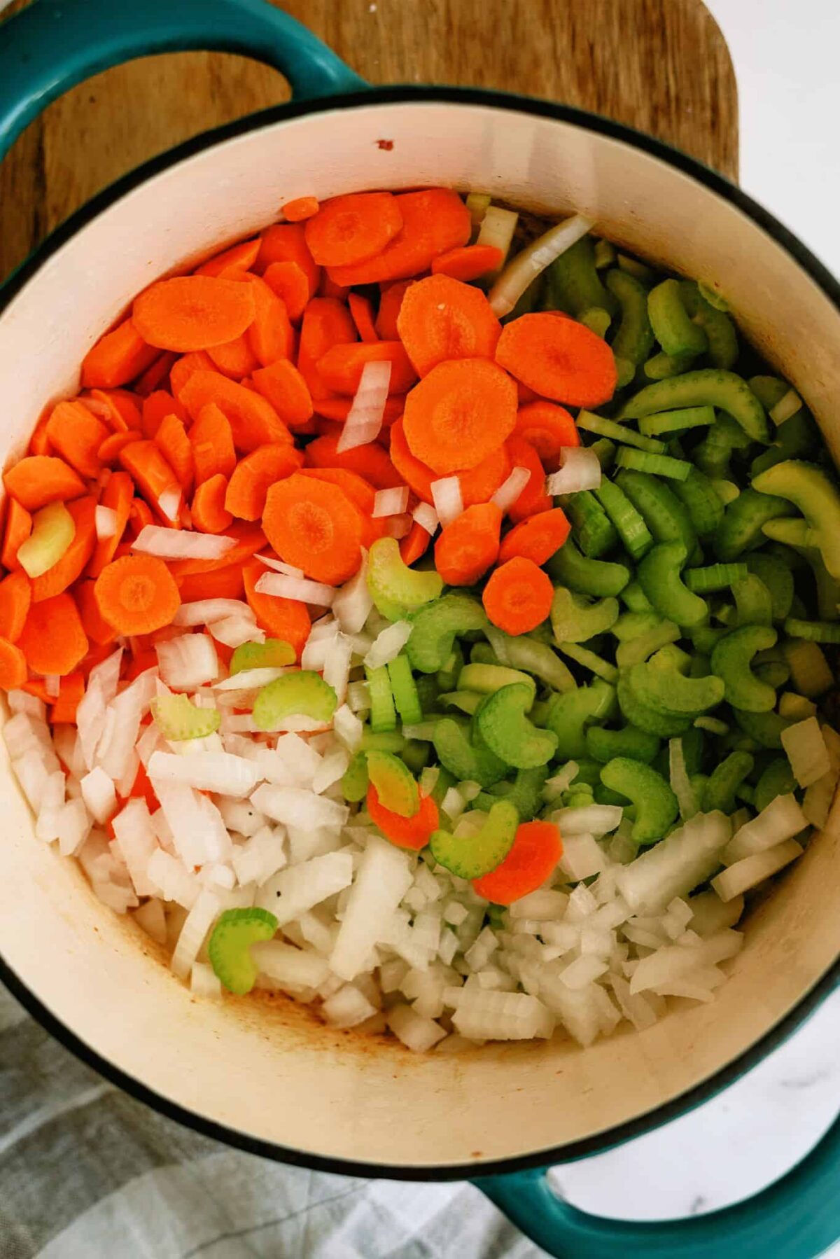 Chopped veggies in the bottom of a stock pot.