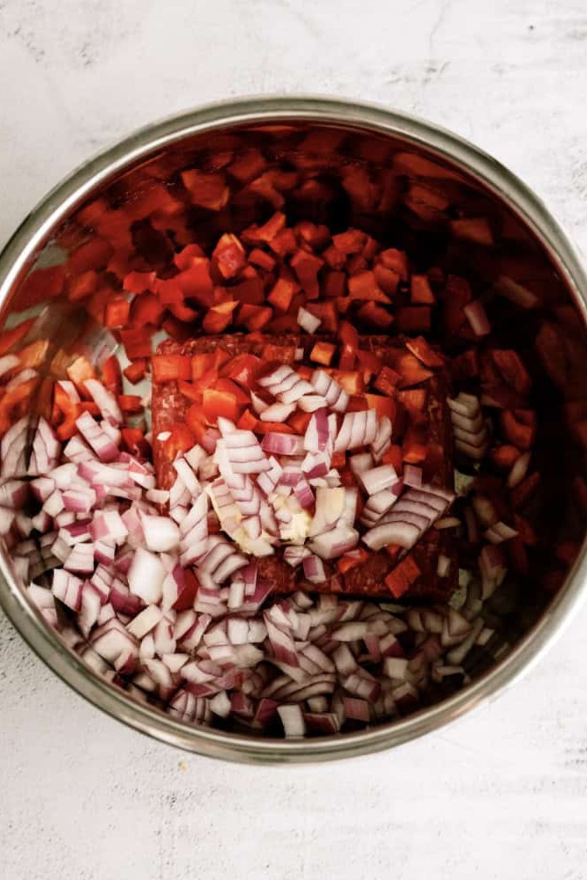 Diced onion, peppers and ground beef in the Instant Pot.