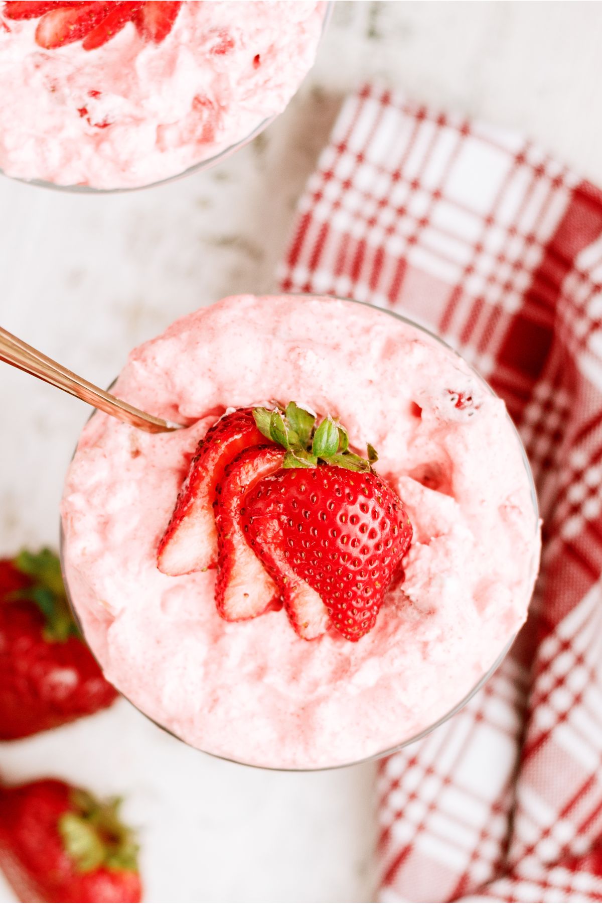 Top view of 5 Minute Strawberry Jello Salad in a parfait dish topped with a sliced strawberry.