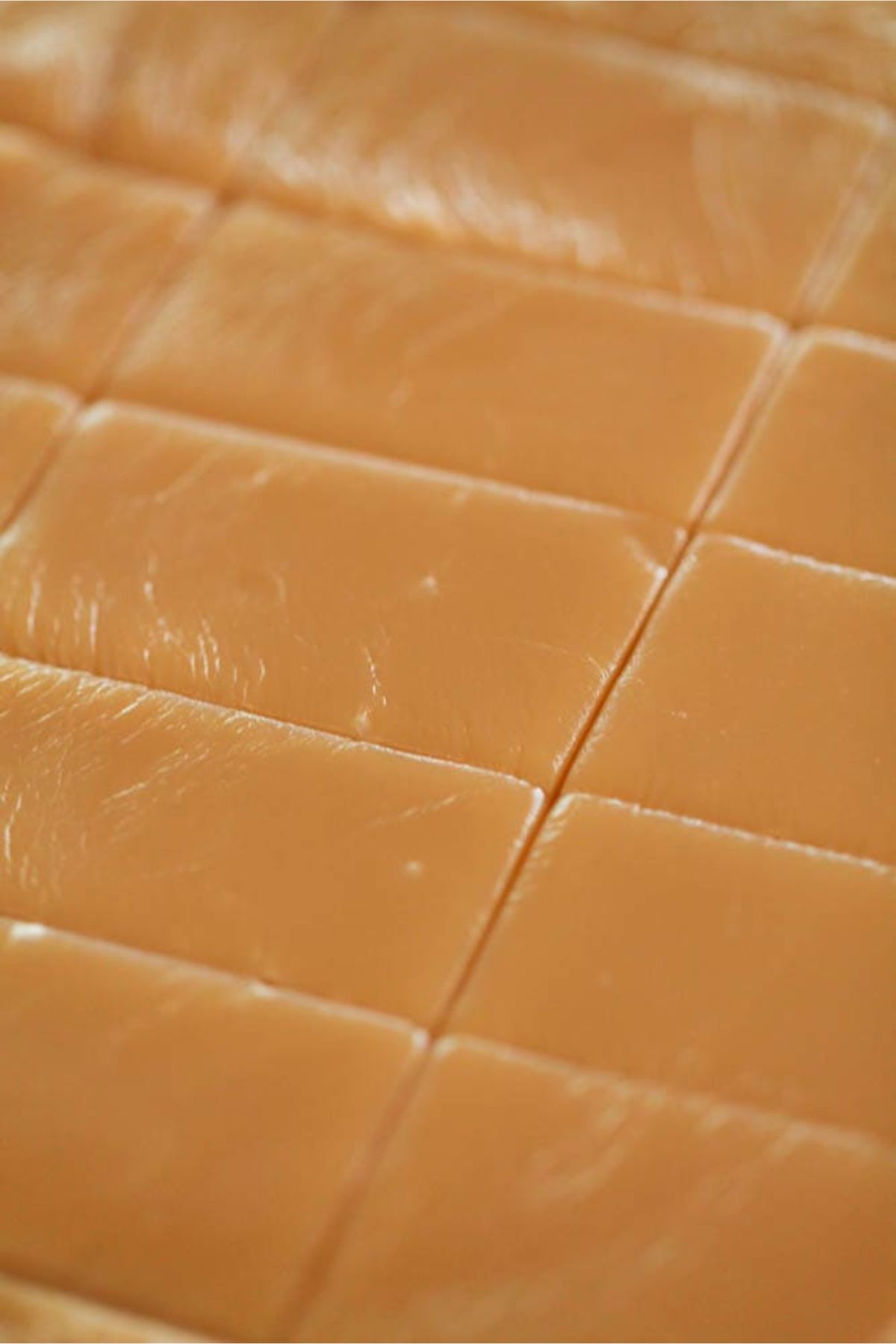 Homemade caramels in a baking dish with lines cut by a knife into portions.