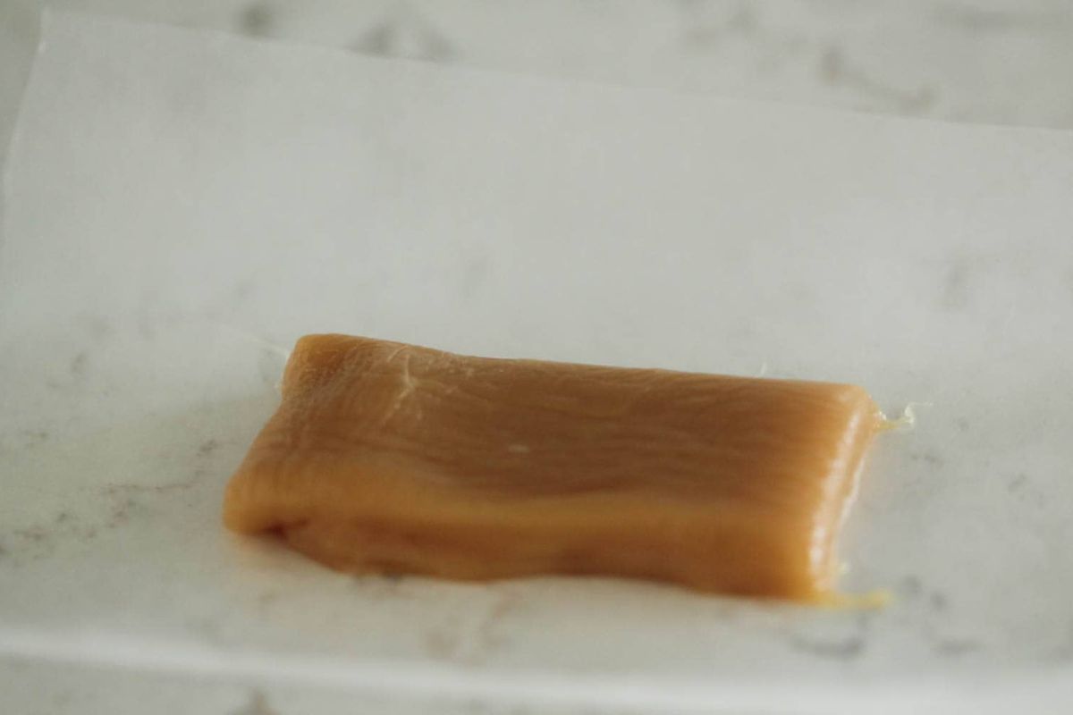 A homemade caramel square waiting to be wrapped.