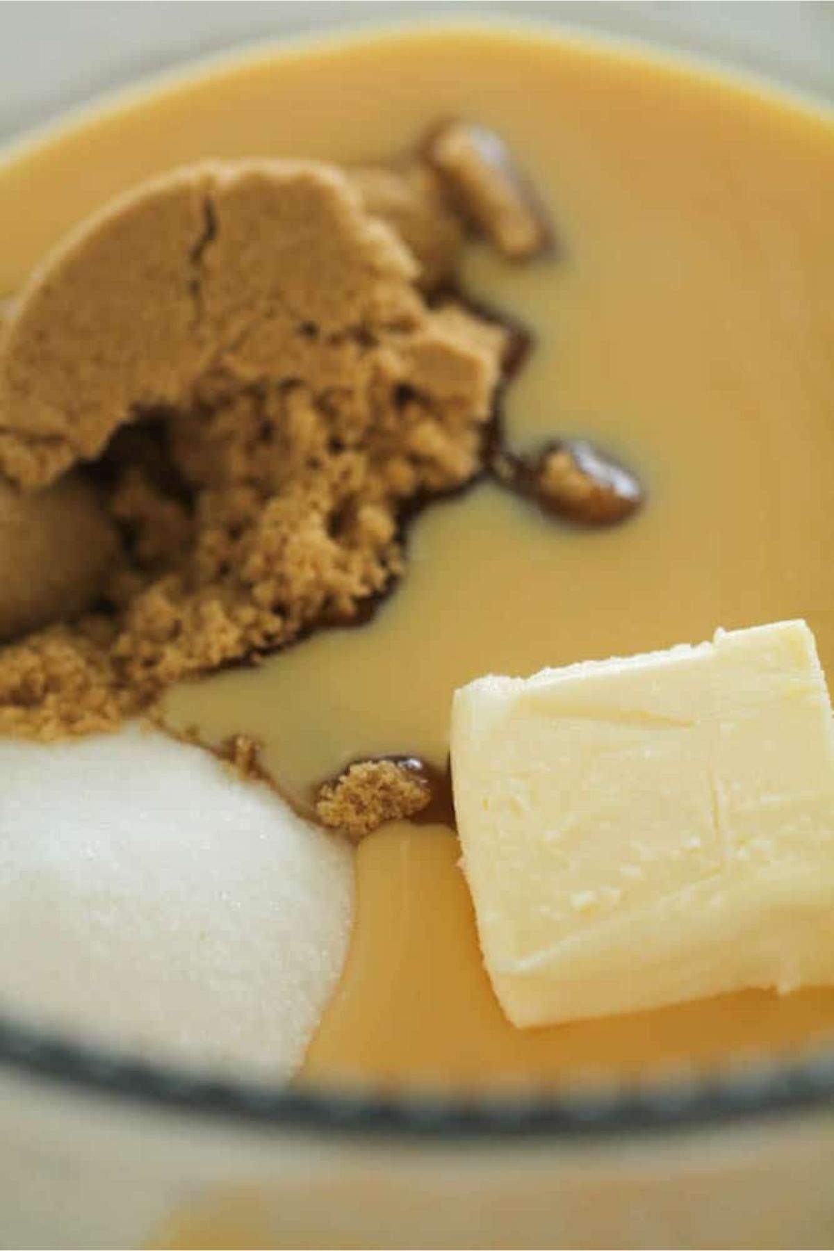 Brown Sugar, Butter, Granulated Sugar and Sweetened Condensed milk in a glass mixing bowl.