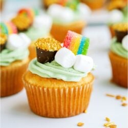 St. Patrick's Day Cupcakes on a countertop with gold sprinkles.