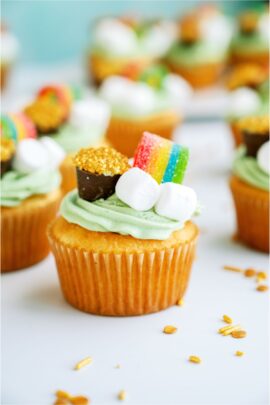 St. Patrick's Day Cupcakes on a countertop with gold sprinkles.