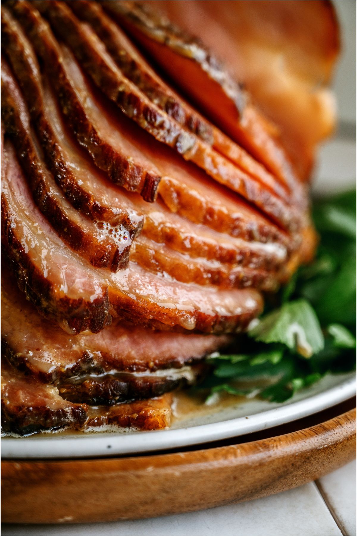 Top view of Crockpot Ham (With Maple Glaze) sliced on a serving plate with garnishes.