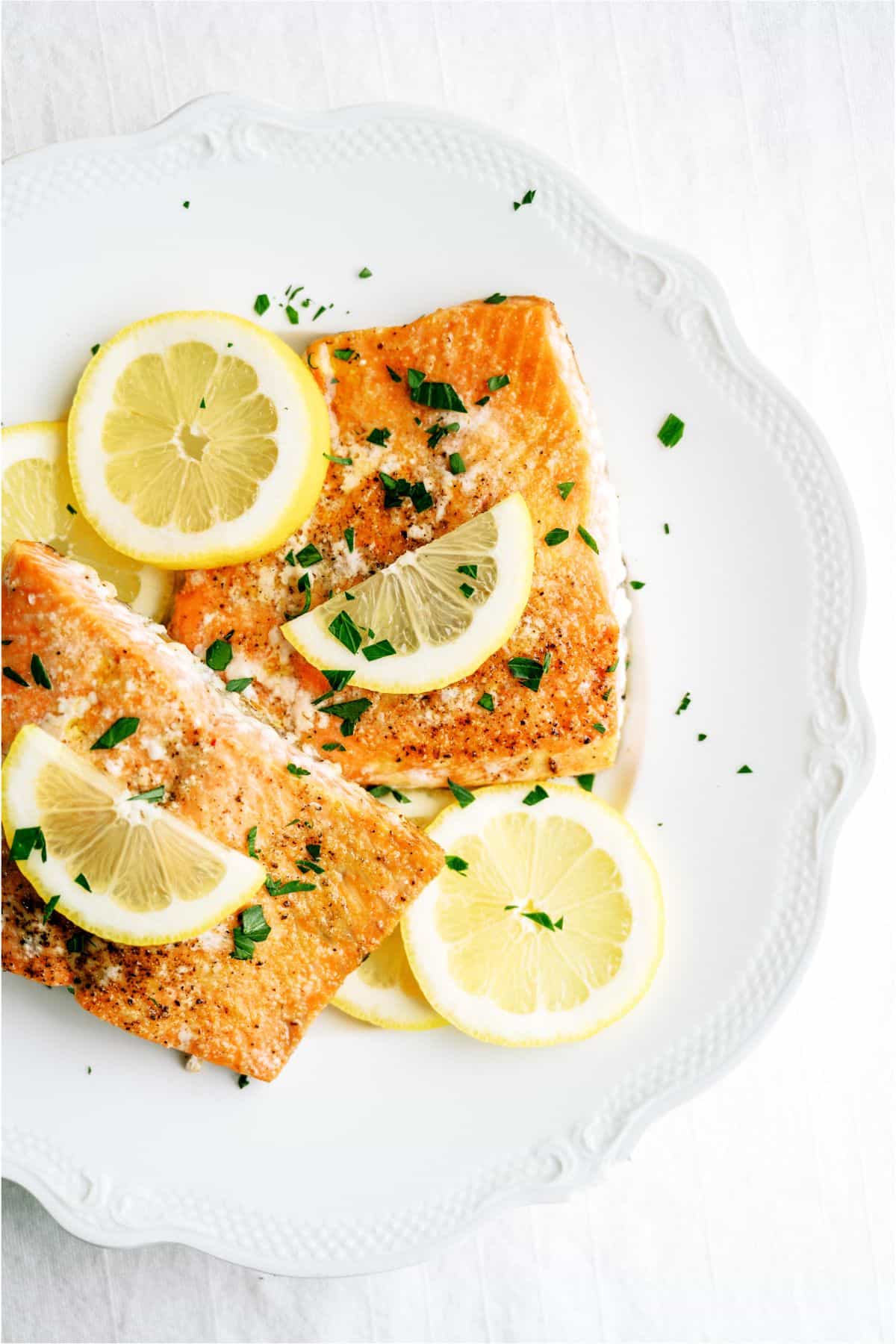 Baked Salmon topped with fresh lemon on a plate