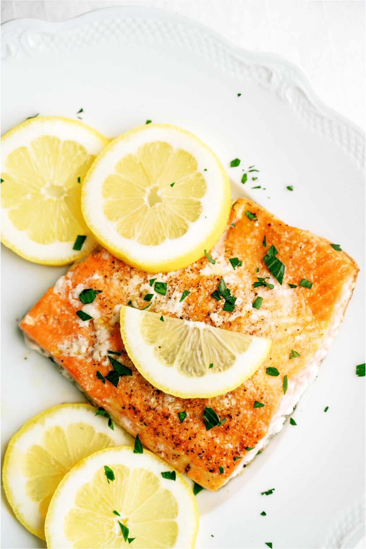 Top view of Baked Salmon on a plate topped with fresh lemon