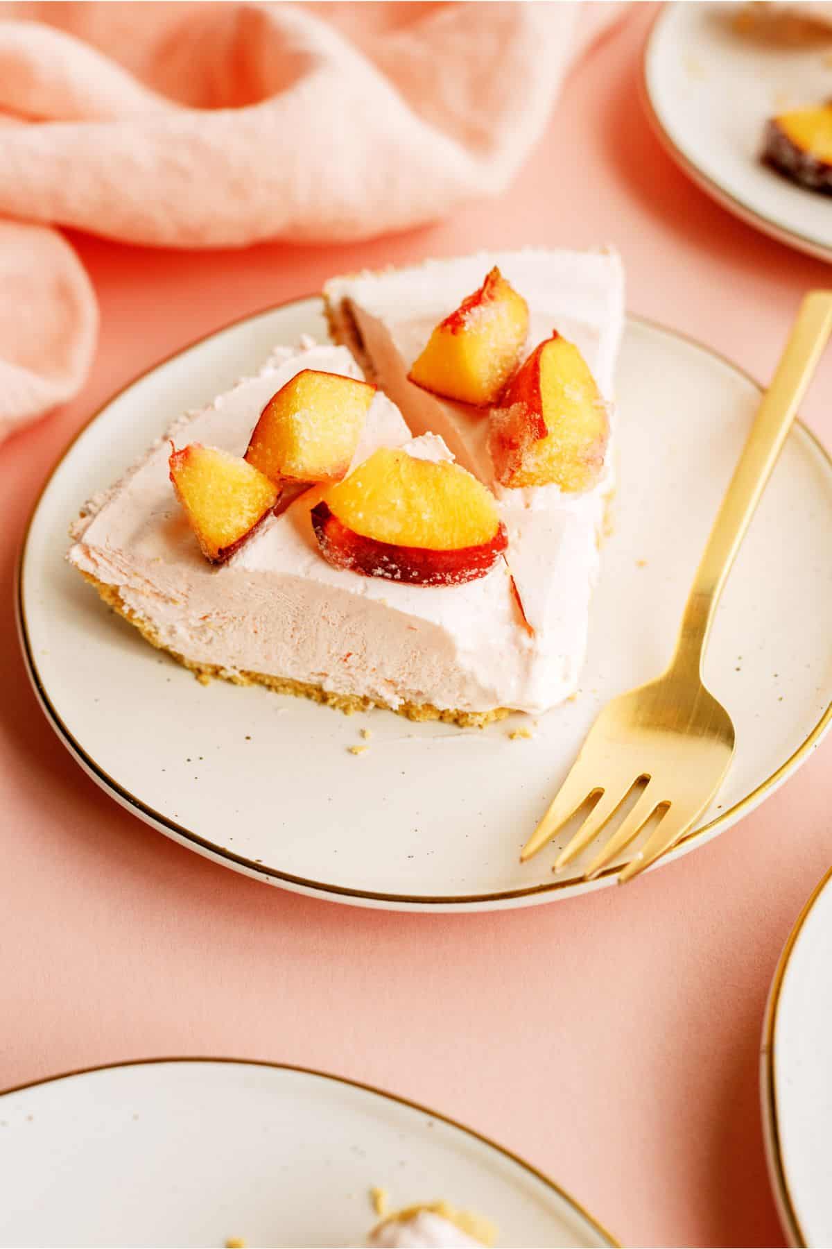 Two slices of Creamy Peach Pie on a plate topped with peaches