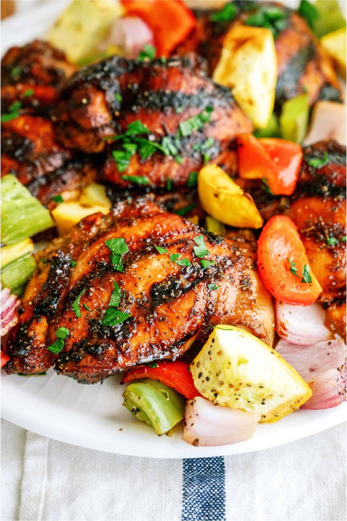 A plate of Grilled Boneless Chicken Thighs and grilled veggies