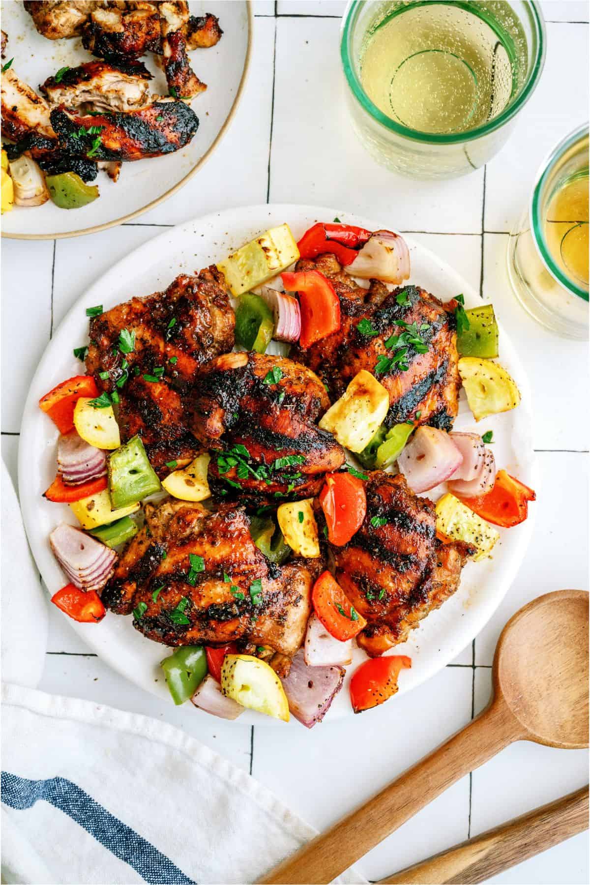 Top view of a plate of Grilled Boneless Chicken Thighs and grilled veggies