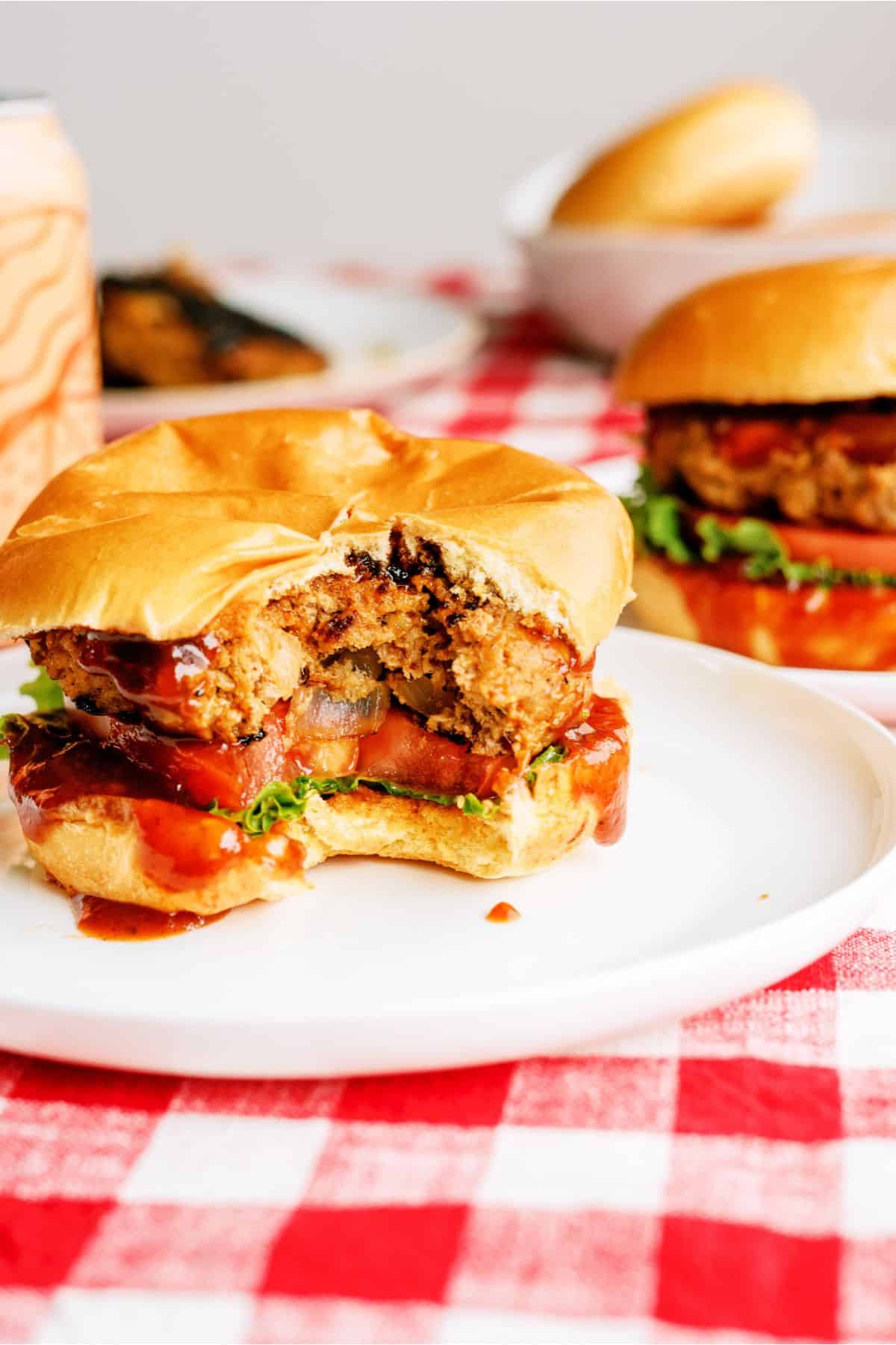 Juicy BBQ Turkey Burgers on plates with a bite missing out of it