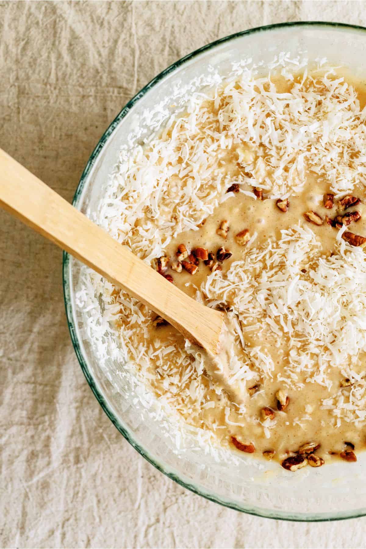 Coconut and pecans added to cake batter in mixing bowl