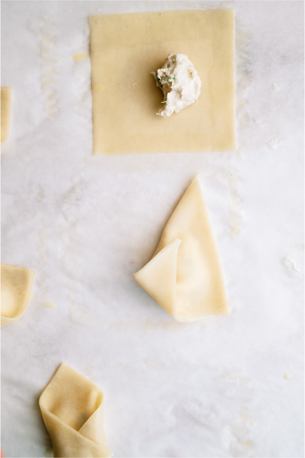 Stages of folding the wonton wrapper into a Baked Crab Rangoon