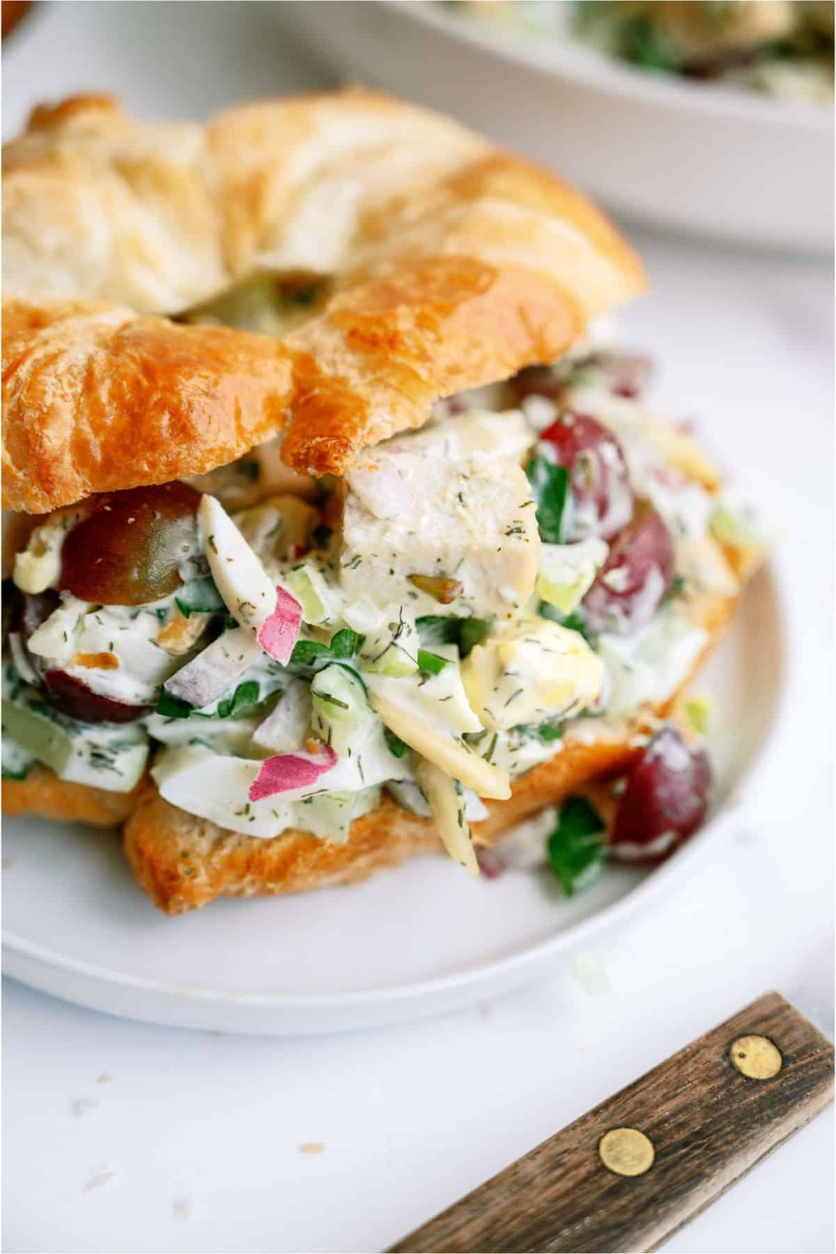 A croissant filled with Chicken Salad with Eggs on a plate