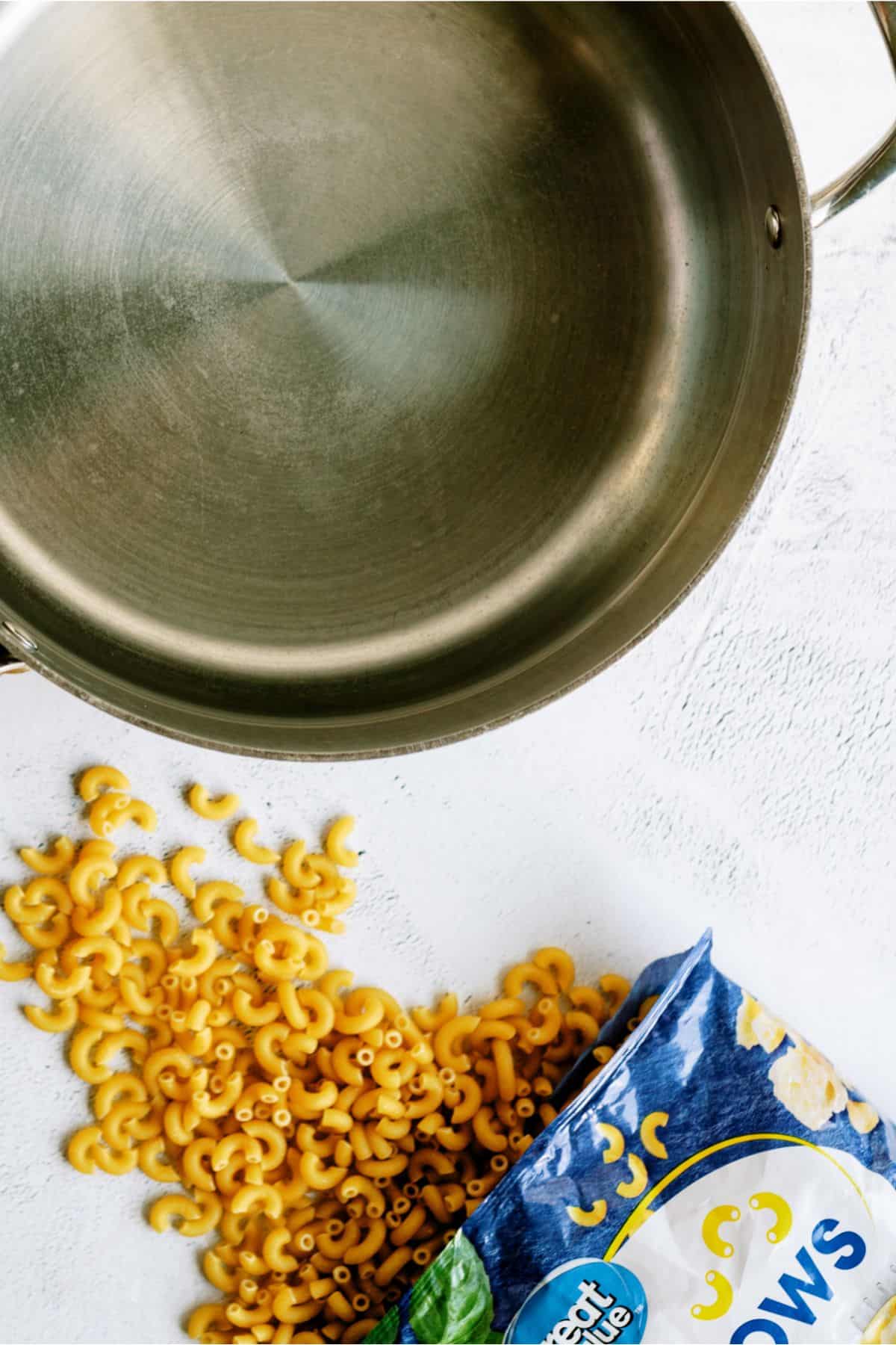 A large pot filled with water and  elbow macaroni on the side