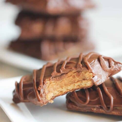 Disneyland’s Chocolate Peanut Butter Sandwich missing a bite on a plate stacked on top of another cookie.