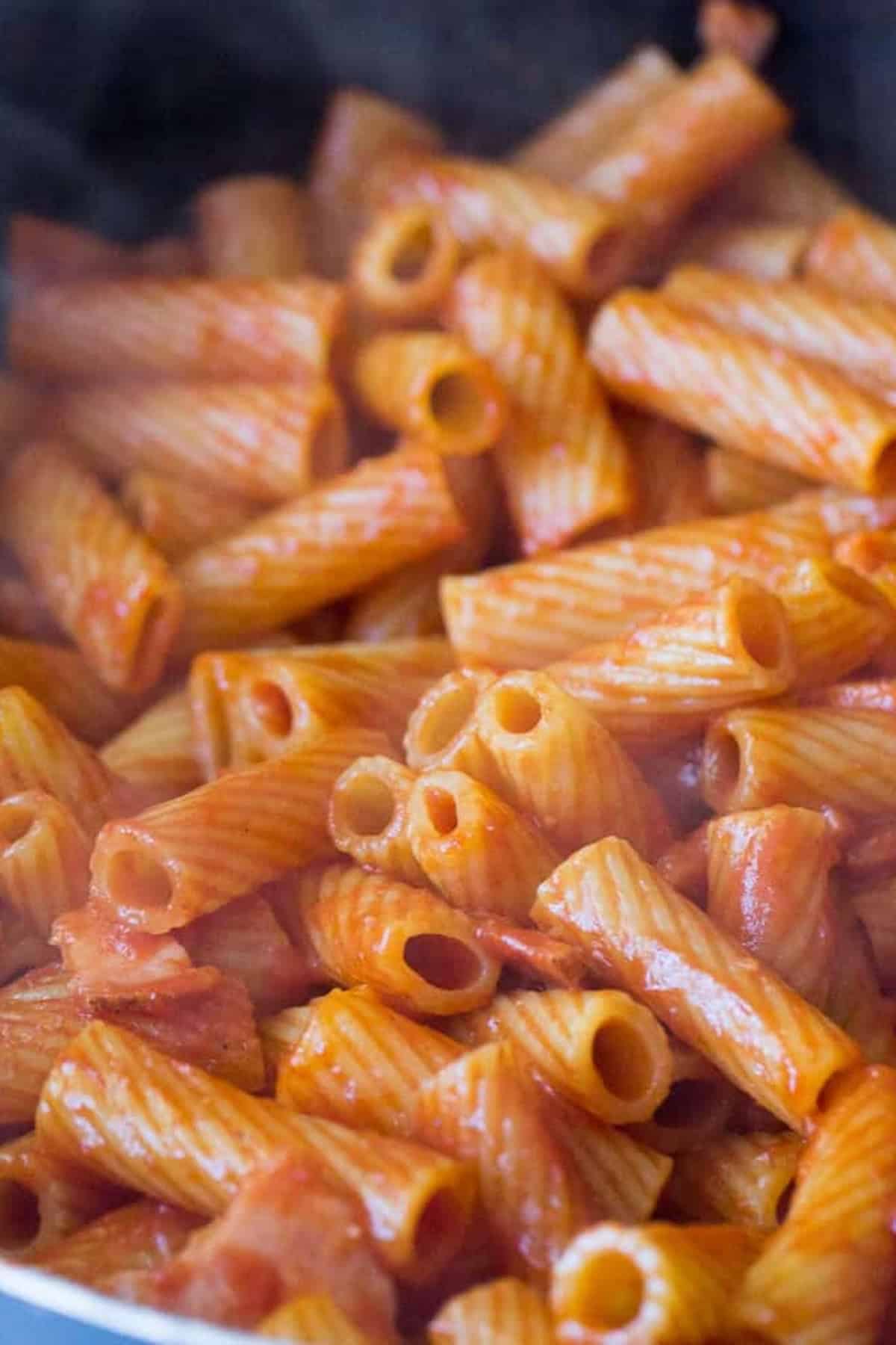 Close-up of cooked rigatoni pasta with marinara sauce.