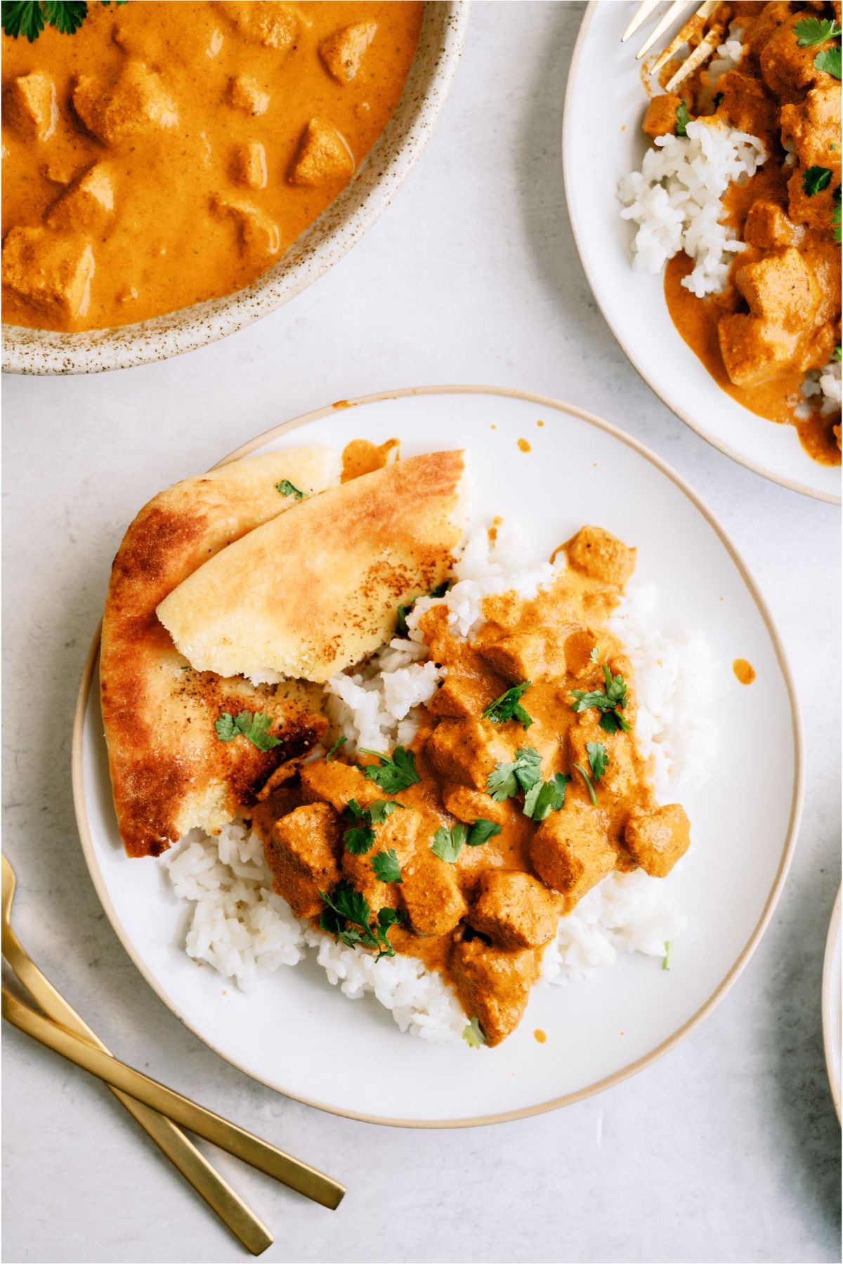 Top view of a plate with a serving of Instant Pot Chicken Tikka Masala over rice and naan bread