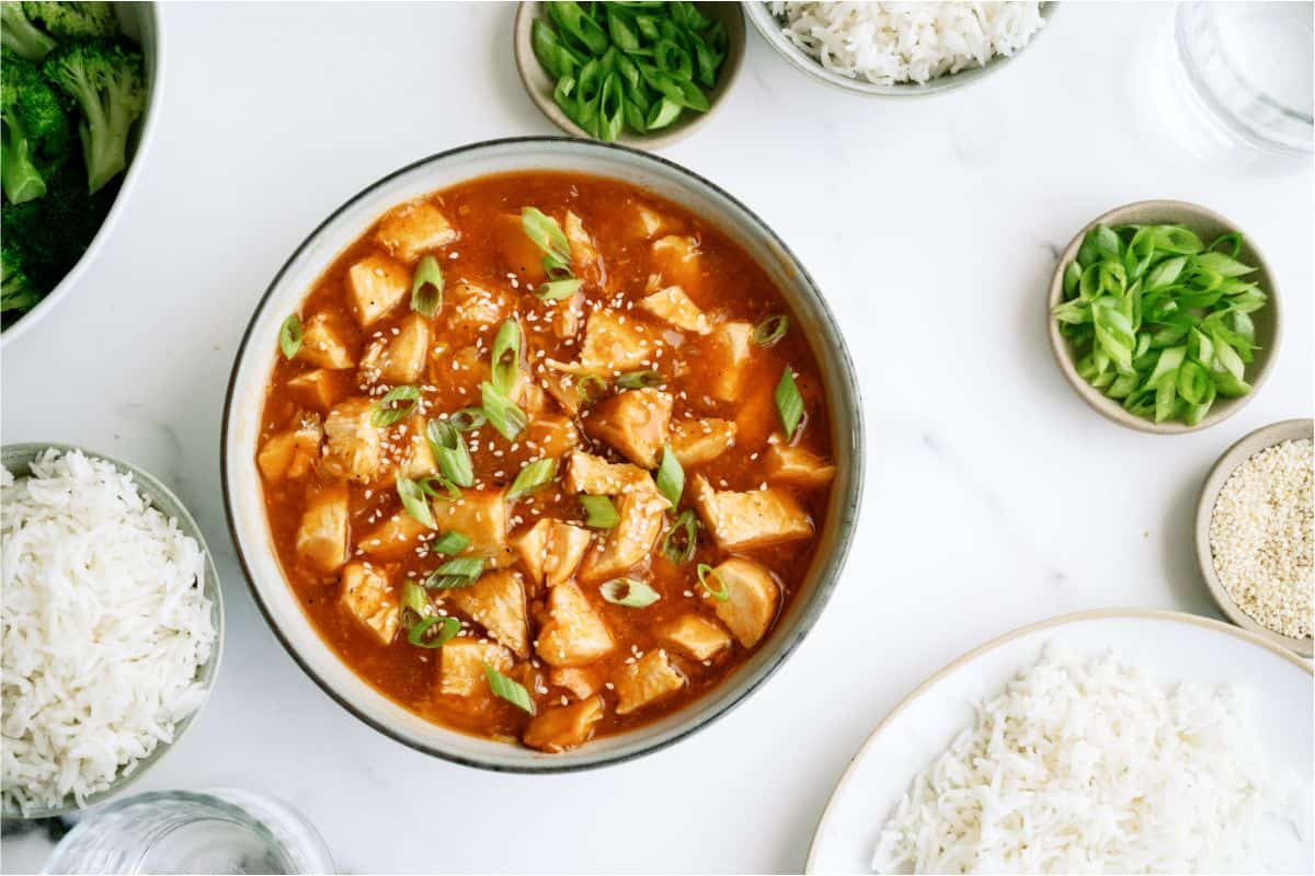 Top view of a bowl of Instant Pot Honey Garlic Chicken surrounded by bowls of rice